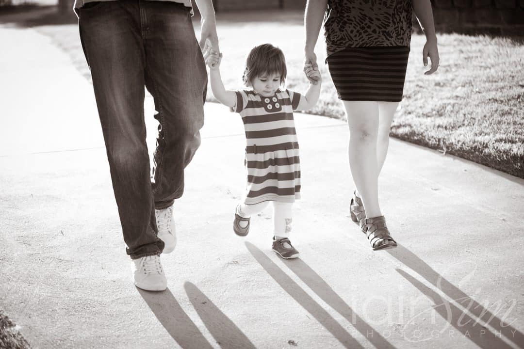 Parents walking baby girl