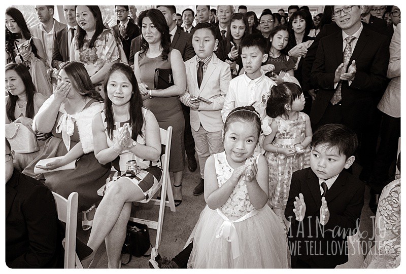 Guests look on and applaud as the bride and groom are pronounced man and wife