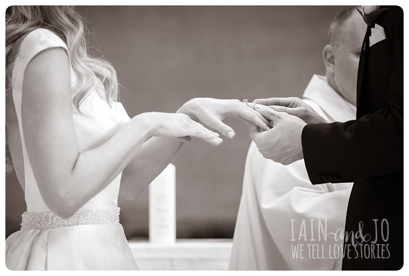 Groom Putting Wedding Ring On Bride's Finger During Ceremony